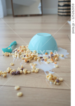 Cereal bowl spills on wooden floor creating a messy cleanup Cereal bowl spills on wooden floor creating a messy cleanup 125262059
