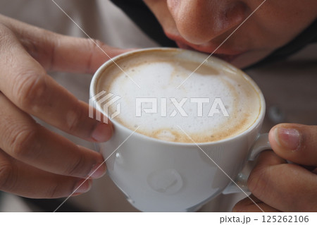 Enjoying a warm cup of coffee in a cozy setting Enjoying a warm cup of coffee in a cozy setting 125262106