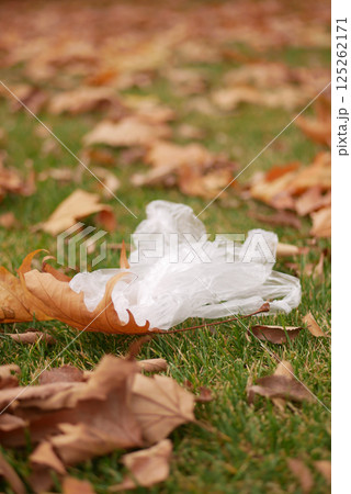 Plastic waste mixed with autumn leaves on a grassy surface Plastic waste mixed with autumn leaves on a grassy surface 125262171