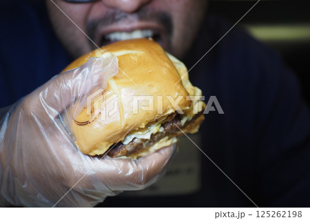Enjoying a juicy burger at a local restaurant during lunch time 125262198