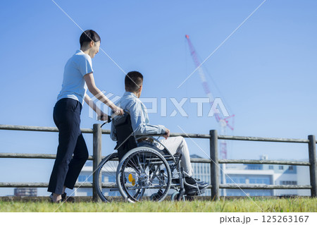 車椅子に乗るシニア男性と介護士 125263167