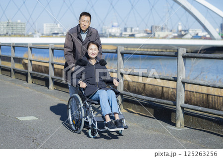 車椅子の妻を介助する夫 車椅子の妻を介助する夫 125263256
