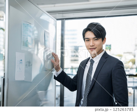 社内プレゼン中にカメラ目線を向けるビジネスマンの一瞬 社内プレゼン中にカメラ目線を向けるビジネスマンの一瞬 125263785