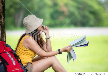 Women hiker oWomen hiker or traveler with backpack adventure holding map to find directions r traveler with backpack adventure holding map to find directions and siting relax Women hiker oWomen hiker or traveler with backpack adventure holding map to find directions r traveler with backpack adventure holding map to find directions and siting relax 125264204