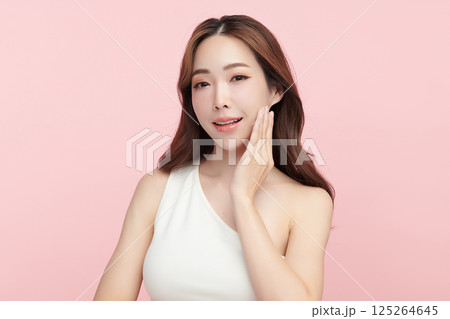 A beautiful young Asian woman with clean, fresh skin against a pink background. Skincare, facial treatment, cosmetology, beauty, and spa. An elegant portrait of an Asian woman. A beautiful young Asian woman with clean, fresh skin against a pink background. Skincare, facial treatment, cosmetology, beauty, and spa. An elegant portrait of an Asian woman. 125264645