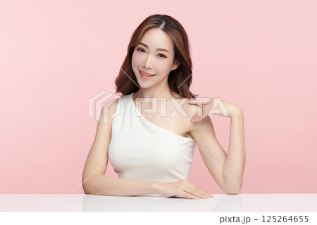 A beautiful young Asian woman with clean, fresh skin against a pink background. Skincare, facial treatment, cosmetology, beauty, and spa. An elegant portrait of an Asian woman. A beautiful young Asian woman with clean, fresh skin against a pink background. Skincare, facial treatment, cosmetology, beauty, and spa. An elegant portrait of an Asian woman. 125264655