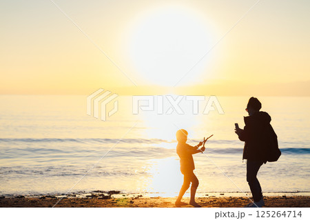 夕日の海で遊ぶ親子 125264714