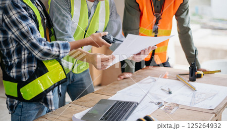 Engineers are discussing data working and laptop or tablet with architectural project at new construction site on big project. Engineers are discussing data working and laptop or tablet with architectural project at new construction site on big project. 125264932
