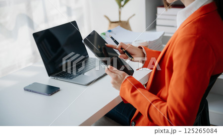 businesswoman working with digital tablet computer and smart phone with financial business strategy layer effect on desk 125265084
