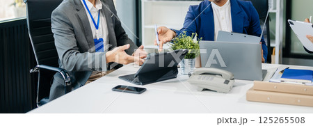 Happy Asian businesspeople while collaborating on a new project. using a laptop and tablet Happy Asian businesspeople while collaborating on a new project. using a laptop and tablet 125265508