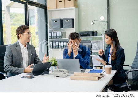 Happy Asian businesspeople while collaborating on a new project.  using a laptop and tablet 125265509
