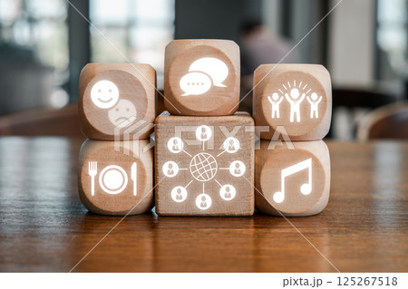 Wooden blocks with icons representing different cultural concepts like communication, music, and social interaction. 125267518
