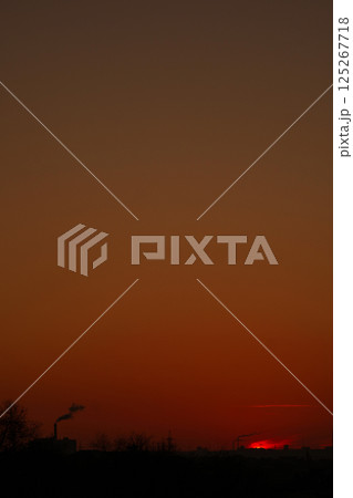 Dark orange skyline with factory smoke twilight hour Dark orange skyline with factory smoke twilight hour 125267718