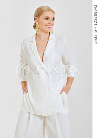 Elegant woman in white attire showcasing stylish fashion trends indoors 125268942
