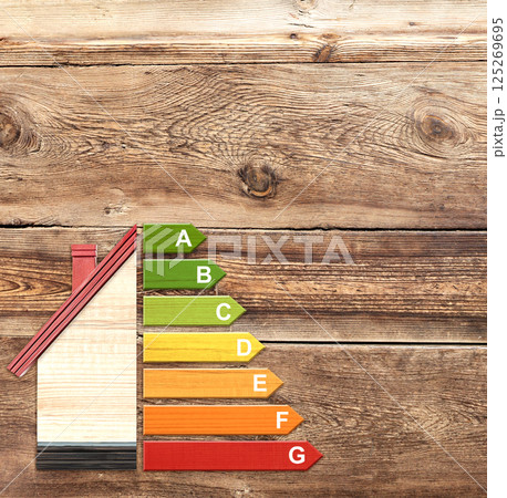 Energy efficiency chart on eco friendly house. Ecology, go green, environmental protection, energy class, bio energetic, energy rating, bio-energy concept. Wooden toy home and energy-saving diagram Energy efficiency chart on eco friendly house. Ecology, go green, environmental protection, energy class, bio energetic, energy rating, bio-energy concept. Wooden toy home and energy-saving diagram 125269695