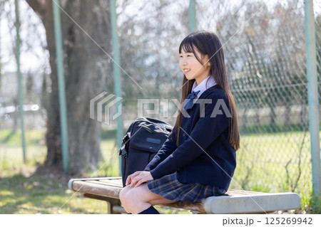 ベンチに座る制服を着た女子学生 125269942