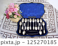 銀製スプーンセットと花かごの静物 125270185