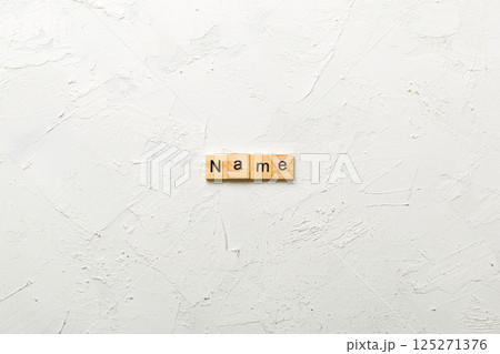 NAME word written on wood block. NAME text on cement table for your desing, concept 125271376