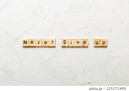 never give up word written on wood block. never give up text on cement table for your desing, concept 125271409