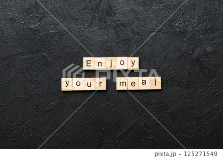 Enjoy your meal word written on wood block. Enjoy your meal text on cement table for your desing, concept Enjoy your meal word written on wood block. Enjoy your meal text on cement table for your desing, concept 125271549