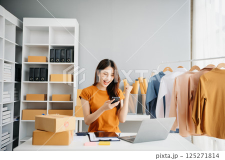Asian lady blogger showing clothes in front of the camera to recording vlog video live streaming at her shop. Online Shopping Asian lady blogger showing clothes in front of the camera to recording vlog video live streaming at her shop. Online Shopping 125271814