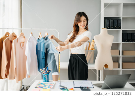Young woman running online store Startup small business SME, using smartphone or tablet taking receive and checking online purchase shopping order 125271832