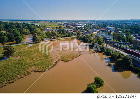 Aerial view of flooded streets, railway tracks and buildings in a suburban area. Industrial zone with floodwater after heavy rain. Concept of natural disaster, climate impact and emergency 125271847