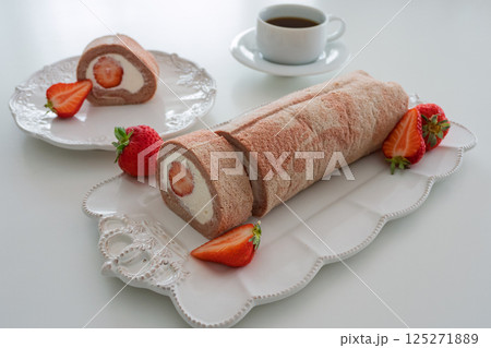 春の苺ロールケーキとコーヒーのティータイム（おしゃれな白い食器とともに） 125271889