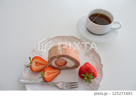 春の苺ロールケーキとコーヒーのティータイム（おしゃれな白い食器とともに） 125271891