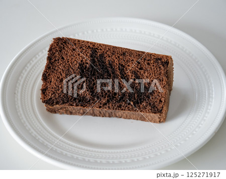 マーブル模様のチョコレートシフォンケーキ（白いプレートに映えるふわふわ焼き菓子） 125271917