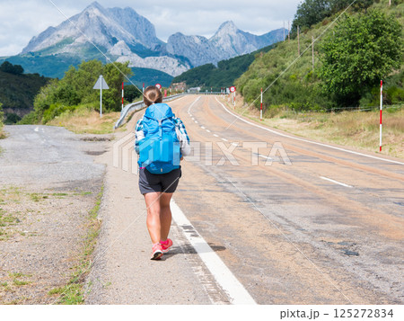 Lonely Pilgrim with backpack walking the Camino de Santiago, ruta Vadiniense. Way of St James Lonely Pilgrim with backpack walking the Camino de Santiago, ruta Vadiniense. Way of St James 125272834