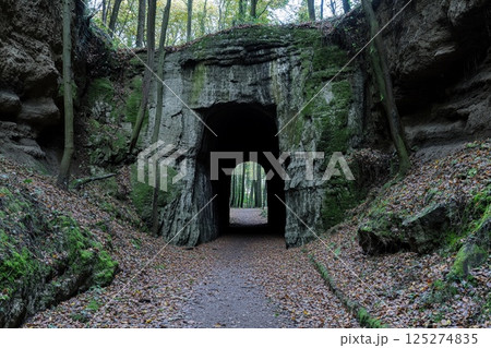 Majestic portal to another world glows amidst ethereal landscape with rolling clouds and sunlit greenery 125274835