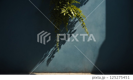 Minimalistic background with green plant branch and blurred foliage shadow on wall 125275451