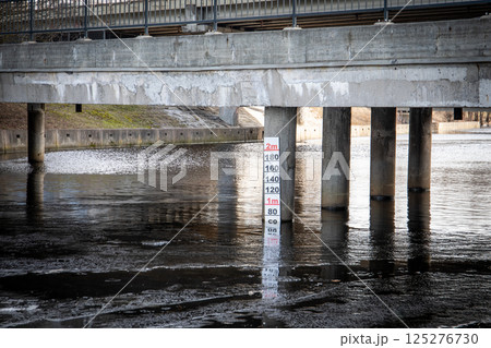 Concrete Bridge with Depth Marker Reflected in the Water Below Concrete Bridge with Depth Marker Reflected in the Water Below 125276730