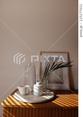 Close-up of the aesthetic details of the home interior. Ceramic tray on a wooden chest of drawers in the bedroom 125277012