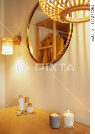 Two lighted candles in a ceramic and glass candlestick on a wooden table. Two lighted candles in a ceramic and glass candlestick on a wooden table. 125277063