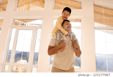 A cute little boy is sitting on the shoulders of his smiling father. A cute little boy is sitting on the shoulders of his smiling father. 125277067