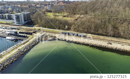 Tram-train driving along the coast, close to the Troejborg area in Aarhus 125277325