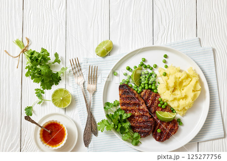 grilled beef cutlets with potato mash, green peas 125277756
