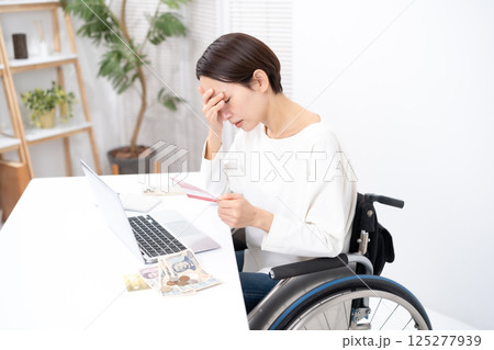 車椅子の女性　お金　通帳　悩む 125277939