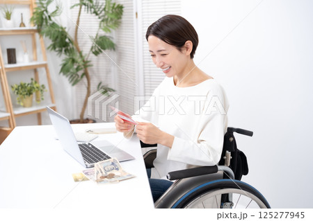 車椅子の女性 お金 通帳 悩む 車椅子の女性 お金 通帳 悩む 125277945