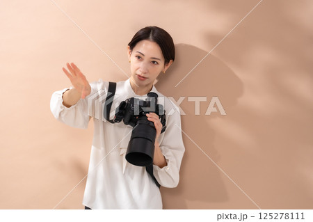 女性　ベージュバック　カメラ 125278111