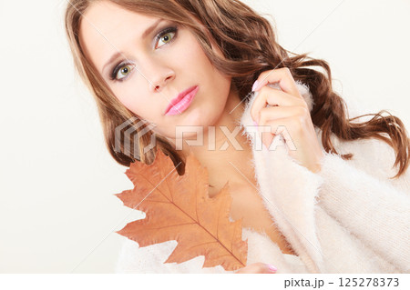 Pretty autumnal girl with oak leaf in hand Pretty autumnal girl with oak leaf in hand 125278373