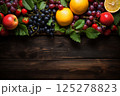 still life with bunches of grapes, berries and fresh and juicy fruits against a dark old wooden background, rural vintage style, the concept of fresh and healthy food 125278823