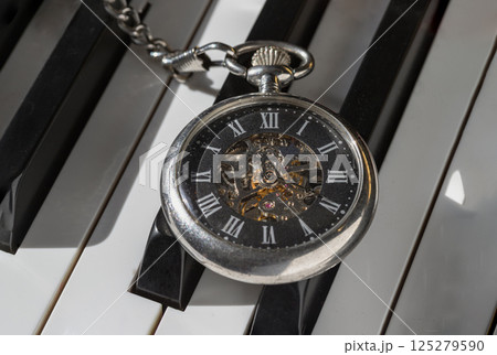 Antique pocket watch or Retro pocket watch on Piano keys background. Antique pocket watch or Retro pocket watch on Piano keys background. 125279590