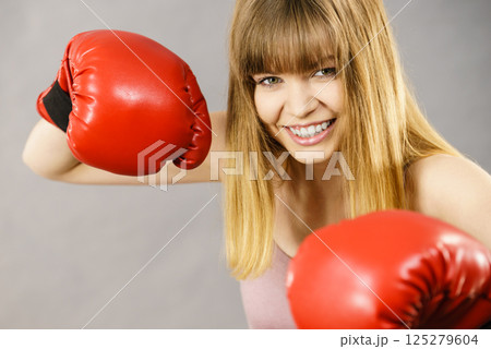 Cheerful woman wearing boxing gloves 125279604