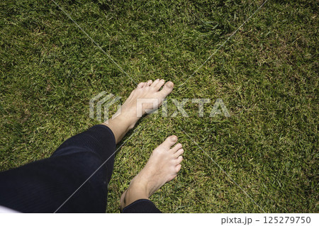 Naked female feets on the lawn Naked female feets on the lawn 125279750