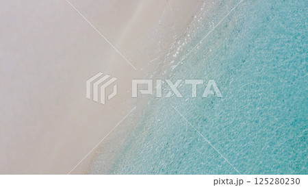 Aerial view of the beach and the blue sea water. Beautiful seascape. Calm ocean waves and clean sand. Rest, relaxation and vacation. Aerial view of the beach and the blue sea water. Beautiful seascape. Calm ocean waves and clean sand. Rest, relaxation and vacation. 125280230