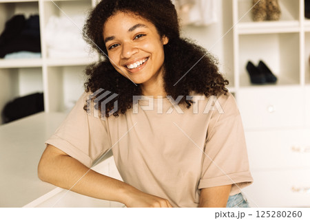 A close-up portrait of a young smiling teenage girl of mixed race in a home dressing room 125280260