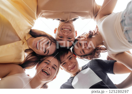 Funny smiling teenagers standing and looking down at camera 125280297